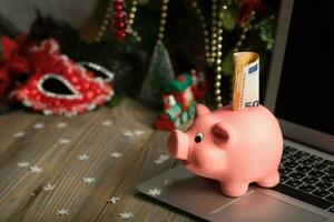 Rosa Schweinchen Bank mit Banknote auf ein Laptop. foto