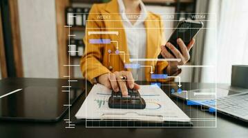 Arbeits- und Aktualisierungsaufgaben des Projektmanagers mit Meilenstein-Fortschrittsplanung und Gantt-Diagramm-Planungsdiagramm. geschäft, das mit smartphone, tablet und laptop im büro arbeitet. foto