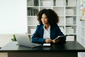 afrikanisch Frau Freiberufler ist Arbeiten ihr Job auf Computer Tablette und Laptop tun Buchhaltung Analyse Bericht echt Nachlass Investition Daten, finanziell beim Büro foto