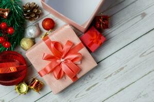 Nahansicht von Rosa Geschenk Box und Weihnachten Komposition auf ein Holz Hintergrund. Layout Weihnachten Hintergrund Konzept. foto