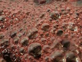 Kirsche Marmelade. Sieden Marmelade Oberfläche. Hintergrund von Luftblasen auf Kirsche Marmelade foto