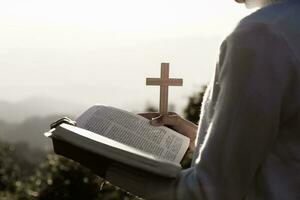 Hände einer christlichen Frau, die eine Bibel und ein Kreuz hält, während sie zu Gott beten, religiöse Überzeugungen, Kopienraum. foto