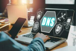 DNS, Domain Name System Server Konzept, Person Hand Arbeiten auf Laptop Computer mit Domain Name System Server Symbol auf virtuell Bildschirm, gemischt Medien. foto