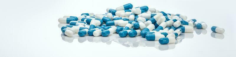Blau Weiss Antibiotikum Kapsel Tabletten auf Weiß Hintergrund. Stapel von Antibiotikum Arzneimittel. Antibiotikum Droge Widerstand. Rezept Drogen. Gesundheitswesen und Medizin. pharmazeutische Industrie. Apotheke Produkt. foto