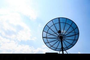 Satellitenschüssel auf dem Dach und blauer Himmel in der Nachmittagssilhouette foto