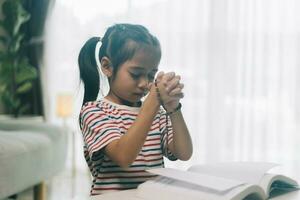 wenig asiatisch Kind Mädchen beten zum Gott beim heim. foto