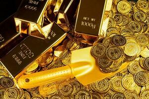 golden Schaufel schöpfen oben Haufen von Gold Münzen und Stapel von Gold Riegel foto
