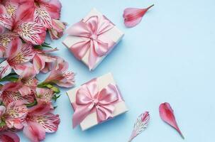 schön Alstroemeria Blumen und Geschenk Kisten auf Blau Hintergrund foto