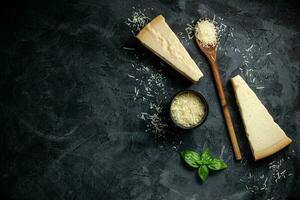 einstellen von schwer Käse mit Käse Messer auf schwarz Stein Hintergrund. Parmesan. oben Sicht. kostenlos Raum zum Ihre Text. foto