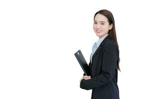 jung asiatisch Fachmann Arbeiten Frau im ein schwarz passen hält Zwischenablage im ihr Hände und zuversichtlich lächelt während isoliert auf Weiß Hintergrund. foto