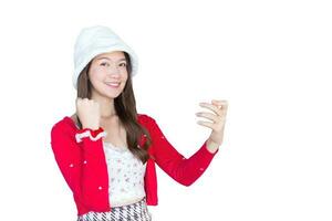 schön jung asiatisch Frau Wer trägt rot Mantel und Weiß Hut wie santy Mädchen hält Smartphone oder andere im ihr Hand und Ein weiterer Handlung während froh und heiter lächelnd auf das Weiß Hintergrund. foto