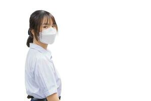 schön jung asiatisch Schüler Mädchen im Uniform ist Gehen zu Schule im das Morgen während tragen ein Maske zum Staub, covid-19 Schutz und gut Hygiene während isoliert auf Weiß Hintergrund.. foto