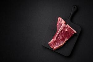 roh saftig Rindfleisch T-Bone Steak mit Salz, Gewürze und Kräuter foto