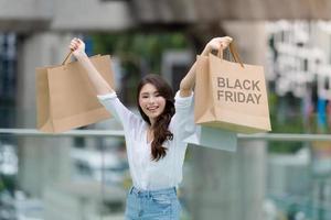 Konzept des schwarzen Freitags, Frau, die viele Einkaufstüten hält und lächelt
