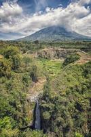 indonesische Landschaft in Zentraljave. Blick auf den Vulkan Merapi und den Wasserfall Air Terjun Kedung Kayang
