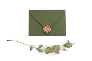 grüner Umschlag mit Designerkarton und Siegel auf weißem Hintergrund. Umschlag mit Siegel foto