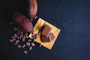 Schokolade und Kakaobohnen mit Kakao auf schwarzem Hintergrund foto