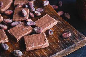 Schokolade und Kakaobohnen mit Kakao auf schwarzem Hintergrund foto