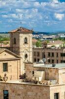 Störche Verschachtelung auf oben von das Glocke Turm von Kirche von carmen de abajo gebaut auf das 15 .. Jahrhundert im das Stadt von Salamanca im Spanien foto