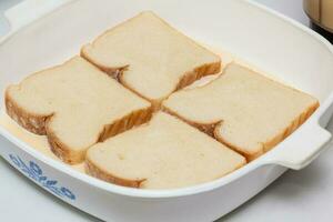 Französisch Toast Vorbereitung. Einweichen Brot im das mischen zum Französisch Toast Vorbereitung foto