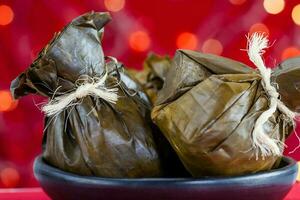 traditionell kolumbianisch Tamale wie gemacht auf tolima Region Über ein Weihnachten rot Hintergrund foto