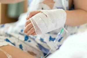 schließen oben Kind Hand mit Kochsalzlösung iv Lösung im Krankenhaus foto