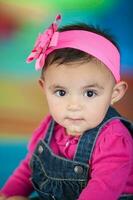 Porträt von ein schön zehn Monate Baby Mädchen auf ein bunt Hintergrund. früh Stimulation zum Kleinkinder Konzept. foto