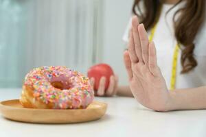 Ernährung und Diät. schönheit schlank weiblicher körper verwirren donut. frau in trainingskleidung erreicht gewichtsverlustziel für ein gesundes leben, verrückt nach dünnheit, dünner taille, ernährungsberaterin. foto