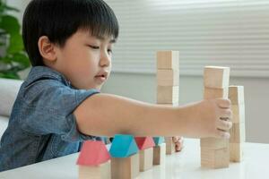 glücklich asiatisch Junge spielen und Lernen Spielzeug Blöcke. Kinder sind sehr glücklich und aufgeregt beim heim. Kind haben ein großartig Zeit spielen, Aktivitäten, Entwicklung, Beachtung Defizit Hyperaktivität Störung foto