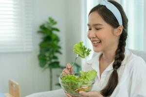 gesund Lebensmittel. schön weiblich Mädchen lächelnd genießen Essen frisch Gemüse Salat auf Frühstück Gesundheit. glücklich asiatisch Frau gut Emotion. Diät, Entgiftung, Diät, verlieren Gewicht, sauber essen, Vegetarier, Ernährungsberater foto