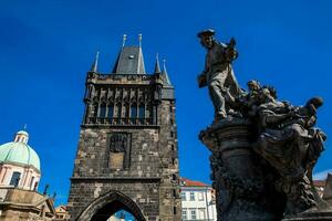 Antiquität Skulptur von ivo von Kermartin und Turm von das mittelalterlich gotisch Charles Brücke im Prag gebaut auf das 15 .. Jahrhundert foto