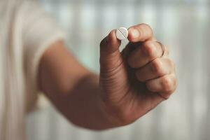 asiatisch Frau Hand halten ein Weiß Pille zum medizinisch und Gesundheitswesen Konzept. foto