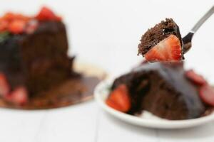 ein Stück von köstlich Erdbeere und Schokolade Kuchen mit rostfrei Gabel foto