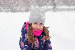 Porträt eines kleinen Mädchens im Schnee foto
