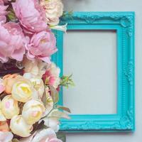 Komposition aus dekorativem Bilderrahmen und pastellfarbenen Blumen mit Kopierraum foto