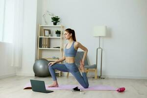 Frau Zuhause Ausbildung Lotus Yoga Lebensstil Video Laptop Gesundheit Fitnessstudio Matte foto