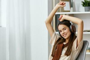 Musik- Telefon Lächeln Teenager Stuhl Lebensstil Kopfhörer Meditation glücklich Mädchen foto