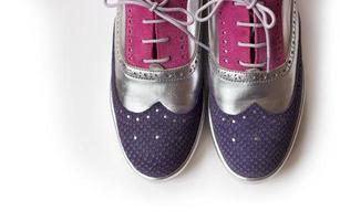 Blick von oben auf die violetten, silbernen und rosafarbenen Damen-Oxford-Schuhe, isoliert auf weißem Hintergrund foto