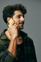 einer Mann Lächeln Hemd stilvoll glücklich Telefon Studio Hintergrund attraktiv Technologie Mode Hör mal zu grau Lebensstil foto