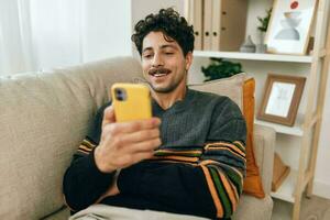 Tippen Mann Botschaft männlich Lebensstil Zuhause Kommunikation Technologie Telefon Sofa beiläufig freiberuflich foto