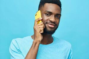 Mann glücklich Telefon Technologie lächelnd Handy, Mobiltelefon jung Gelb Lächeln schwarz Hintergrund afrikanisch foto