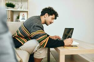 online Mann Internet jung Arbeiten Lächeln Geschäft Computer freiberuflich Laptop einer Glück Couch Zuhause foto