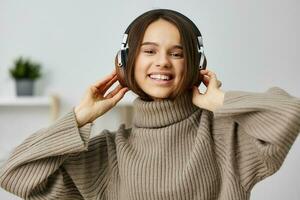 jung Frau glücklich Musik- Innen- Freude Schüler Kopfhörer kaukasisch Zuhause Kopfhörer foto