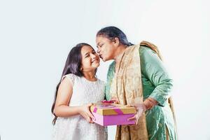 süß wenig indisch Mädchen posieren mit ihr Oma Über Weiß Hintergrund foto