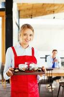 Frau Arbeiten wie Kellnerin halten ein Tablett mit Tee und Kaffee foto