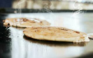 schließen oben von traditionell handgemacht pupusas auf Grill, traditionell nicaraguanisch pupusas mit geschmolzen Käse auf Grill. traditionell gegrillt Käse pupusas foto