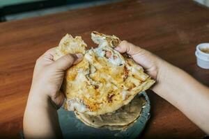 Aussicht von Hände Teilen köstlich salvadoran pupusas auf hölzern Tisch. Konzept von traditionell handgemacht pupusas, Hände Teilen köstlich nicaraguanisch Puppe auf das Tabelle foto