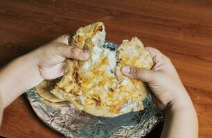 Hände Teilen köstlich nicaraguanisch Puppe auf das Tisch, Aussicht von Hände Teilen köstlich salvadoran pupusas auf hölzern Tisch. Konzept von traditionell handgemacht pupusas foto