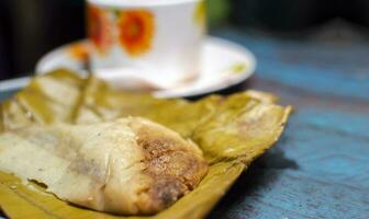 ausgestopft Tamale serviert auf hölzern Tisch, ausgestopft Tamale auf Banane Blatt serviert auf hölzern Tisch, typisch Nicaragua Essen foto