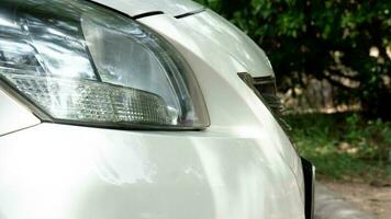 Seite von Vorderseite Weiß Auto schließen oben auf Auto Scheinwerfer. Parkplatz im das Parkplatz viel. foto